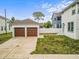Detached two-car garage and well-maintained backyard adjacent to the main house on a sunny day at 444 49Th N St, St Petersburg, FL 33710