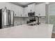 Modern kitchen with stainless steel appliances, white cabinets, and a center island with quartz countertop at 444 49Th N St, St Petersburg, FL 33710