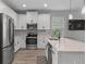 Modern kitchen with stainless steel appliances, white cabinets, and a large island at 444 49Th N St, St Petersburg, FL 33710