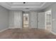 Spacious main bedroom offering tray ceilings, neutral carpet, and access to the ensuite bathroom and walk-in closet at 444 49Th N St, St Petersburg, FL 33710