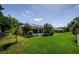 A spacious backyard features a screened-in pool and lush, mature landscaping at 4452 Bardsdale Dr, Palm Harbor, FL 34685