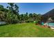 The backyard is spacious and beautifully landscaped near the screened-in pool at 4452 Bardsdale Dr, Palm Harbor, FL 34685