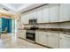 Well-appointed kitchen with granite countertops, white cabinetry, and stainless steel appliances; view to backyard at 4452 Bardsdale Dr, Palm Harbor, FL 34685