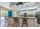 Well-lit kitchen with white cabinetry, granite countertops, stainless steel appliances, and bar seating with backyard views at 4452 Bardsdale Dr, Palm Harbor, FL 34685