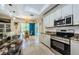 Bright kitchen with white cabinetry, stainless appliances and an adjacent dining area overlooking the pool at 4452 Bardsdale Dr, Palm Harbor, FL 34685