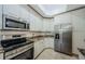 Bright kitchen features white cabinets, stainless steel appliances, and granite countertops at 4452 Bardsdale Dr, Palm Harbor, FL 34685