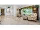 Inviting living room showcasing patterned chairs, a grandfather clock, large windows, and decorative wall accents at 4452 Bardsdale Dr, Palm Harbor, FL 34685
