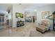 Open-concept living space with tile floors, blue seating, and decorative wall art leading into the kitchen at 4452 Bardsdale Dr, Palm Harbor, FL 34685