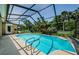 Screened-in pool featuring clear blue water and surrounded by mature trees and landscaping at 4452 Bardsdale Dr, Palm Harbor, FL 34685