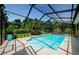 Beautiful pool area enclosed by a screen, with lush landscaping around the perimeter at 4452 Bardsdale Dr, Palm Harbor, FL 34685