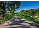 The tree-lined street leads to a stately sign for the community at 4452 Bardsdale Dr, Palm Harbor, FL 34685