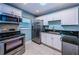 Kitchen with stainless steel oven and microwave, white cabinets, and stainless steel refrigerator at 4805 Alt 19 # 421, Palm Harbor, FL 34683
