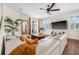 Bright, airy living room with a comfortable white sectional, large windows, and wood flooring at 4808 Jackson Club Loop, Tampa, FL 33624