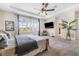 Bright main bedroom featuring plush bedding, a ceiling fan, and ample natural light from shuttered windows at 4808 Jackson Club Loop, Tampa, FL 33624