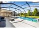 Inviting screened-in pool with a concrete deck, lounge area and view of the green lawn and pond at 4808 Jackson Club Loop, Tampa, FL 33624