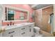 Bright pink bathroom with modern vanity, toilet, and glass-enclosed shower at 5157 Silent Loop # 214, New Port Richey, FL 34652