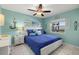 Comfortable bedroom features bright blue bedding, seaside decor, and a ceiling fan at 5157 Silent Loop # 214, New Port Richey, FL 34652