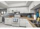 Bright kitchen featuring white appliances and cabinets, stainless steel sink and tile flooring at 5157 Silent Loop # 214, New Port Richey, FL 34652