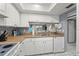 Bright kitchen featuring white appliances and cabinets, stainless steel sink and tile flooring at 5157 Silent Loop # 214, New Port Richey, FL 34652