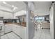 Open-concept kitchen with white cabinets and a view into the adjacent living area and outside at 5157 Silent Loop # 214, New Port Richey, FL 34652