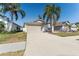 Well-maintained home showcasing a two-car garage and driveway with tropical landscaping at 518 Royal Ridge St, Valrico, FL 33594