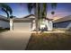 Charming home featuring a two-car garage and a well-manicured lawn with mature palm trees at 518 Royal Ridge St, Valrico, FL 33594