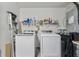 This laundry room is equipped with a washer, dryer, wire shelving, and a step ladder at 518 Royal Ridge St, Valrico, FL 33594