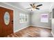 Living room showcasing wood-like flooring, front door, base trim, ceiling fan and two windows at 5324 3Rd N Ave, St Petersburg, FL 33710