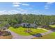 Aerial view of a home surrounded by lush trees and a well-maintained lawn at 5458 Zamia Dr, Brooksville, FL 34604