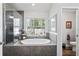 Modern bathroom showcasing a soaking tub, a shower with glass doors, and a serene window view at 5458 Zamia Dr, Brooksville, FL 34604