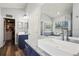 Bright bathroom featuring granite counters, dual sinks, and a large vanity mirror at 5458 Zamia Dr, Brooksville, FL 34604
