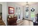 Inviting entryway featuring hardwood floors, stylish lighting, and charming antique furniture at 5458 Zamia Dr, Brooksville, FL 34604