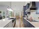 Modern kitchen with stainless steel appliances, navy cabinets, farmhouse sink, and open dining area at 5458 Zamia Dr, Brooksville, FL 34604