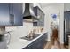 Modern kitchen with stainless steel appliances, navy cabinets, and white countertops at 5458 Zamia Dr, Brooksville, FL 34604