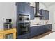 Modern kitchen with stainless steel appliances, navy cabinets, and white countertops at 5458 Zamia Dr, Brooksville, FL 34604