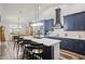 Modern kitchen featuring navy cabinets, a breakfast bar, stainless steel appliances, and dining area at 5458 Zamia Dr, Brooksville, FL 34604