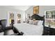 Bright main bedroom with a black wood bed frame, dual doors to the lanai, and plush pillows at 5458 Zamia Dr, Brooksville, FL 34604