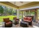 Relaxing covered patio with modern furniture, hot tub and lush green backyard surrounded by trees at 5458 Zamia Dr, Brooksville, FL 34604