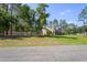 Side view of a home with large front yard and landscaping at 5458 Zamia Dr, Brooksville, FL 34604