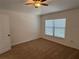 Bright bedroom featuring a ceiling fan, neutral carpet, and large window at 5527 Kinglethill Dr, Lithia, FL 33547