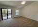 Bright bedroom with neutral carpeting, window, and sliding glass doors leading to an outdoor balcony at 5527 Kinglethill Dr, Lithia, FL 33547