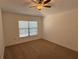 Bedroom featuring a ceiling fan, neutral carpet, and large window at 5527 Kinglethill Dr, Lithia, FL 33547