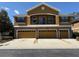 A three-story townhome with a three-car garage and a stucco and stone facade at 5527 Kinglethill Dr, Lithia, FL 33547
