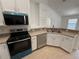 Modern kitchen with stainless steel appliances and white cabinetry, offering a clean and stylish design at 5527 Kinglethill Dr, Lithia, FL 33547