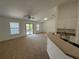Living room with a ceiling fan, sliding glass doors, and a view into the kitchen at 5527 Kinglethill Dr, Lithia, FL 33547