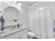 Well-lit bathroom features a white vanity with stone countertop and a shower with a white curtain at 5539 Silver Sun Dr, Apollo Beach, FL 33572