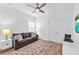 This bedroom is set up as a den with a couch and TV set with a neutral colored rug at 5539 Silver Sun Dr, Apollo Beach, FL 33572