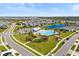 Aerial view of community pool and amenity center, with homes and pond in the background on a sunny day at 5539 Silver Sun Dr, Apollo Beach, FL 33572