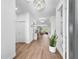 Bright foyer with wood-look tile flooring, modern chandelier lighting, and an open view to the living area at 5539 Silver Sun Dr, Apollo Beach, FL 33572