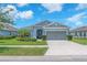 Charming single-story home featuring a well-manicured lawn, lush landscaping, and a two-car garage at 5539 Silver Sun Dr, Apollo Beach, FL 33572